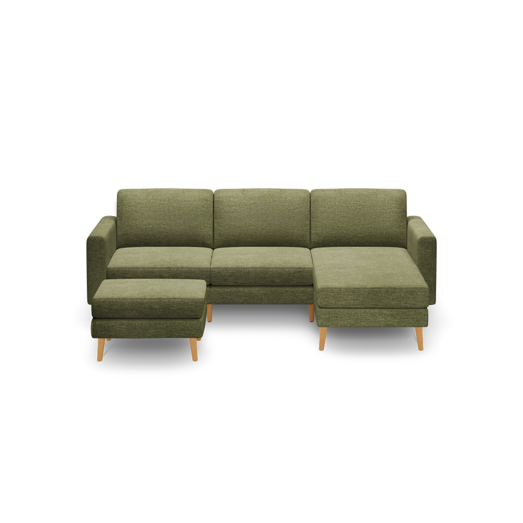 Olive green fabric L-shaped sectional sofa with wooden legs and matching ottoman, modern and minimalistic design.