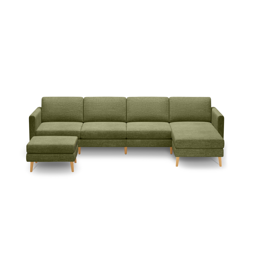 Green fabric sectional sofa with wooden legs, consisting of five seats and a matching ottoman against black background.