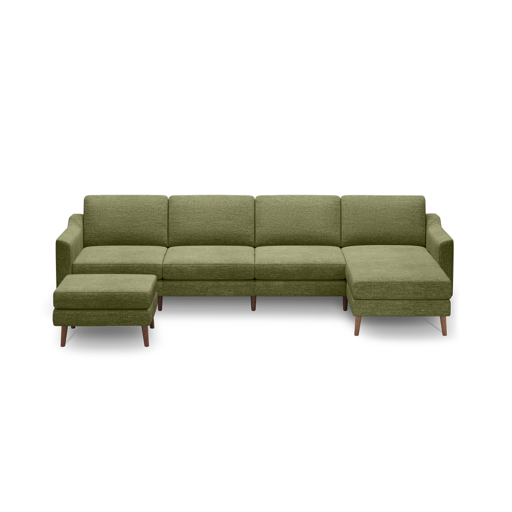 Modern L-shaped sectional sofa in olive green fabric with wooden legs and a matching ottoman against a black background.
