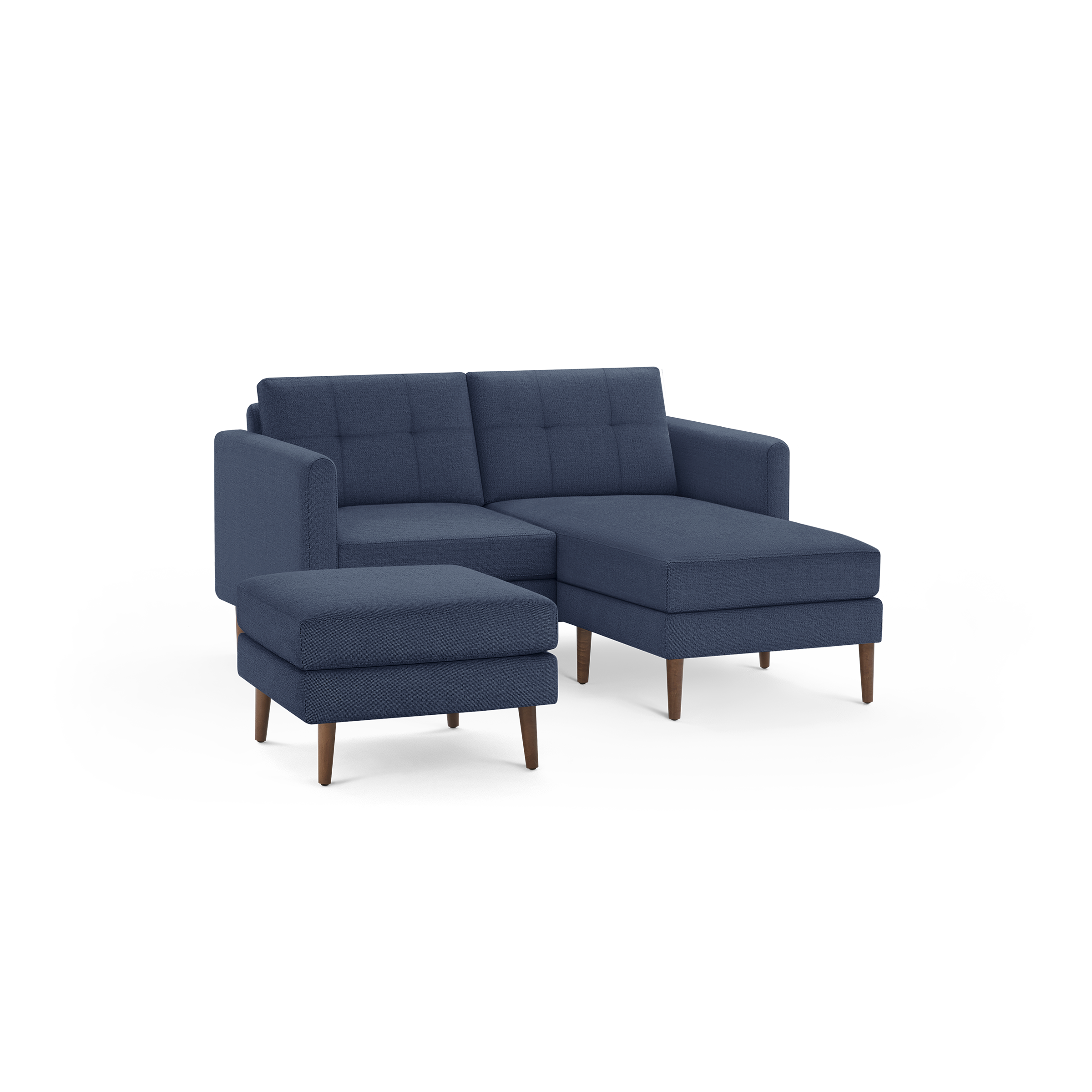 Modern navy blue fabric sectional sofa with tufted cushions and matching ottoman on wooden legs, isolated on black background.