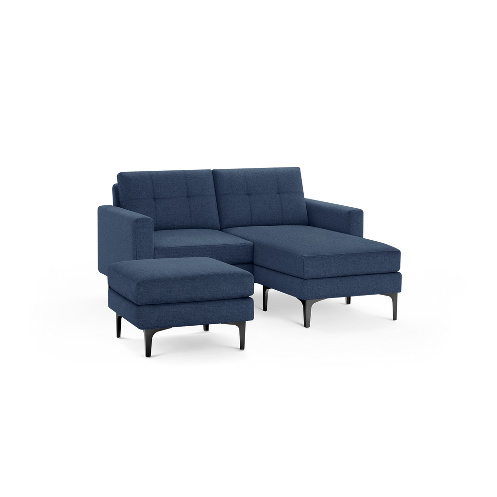 Modern navy blue fabric sectional sofa with chaise lounge and matching ottoman on black metal legs.