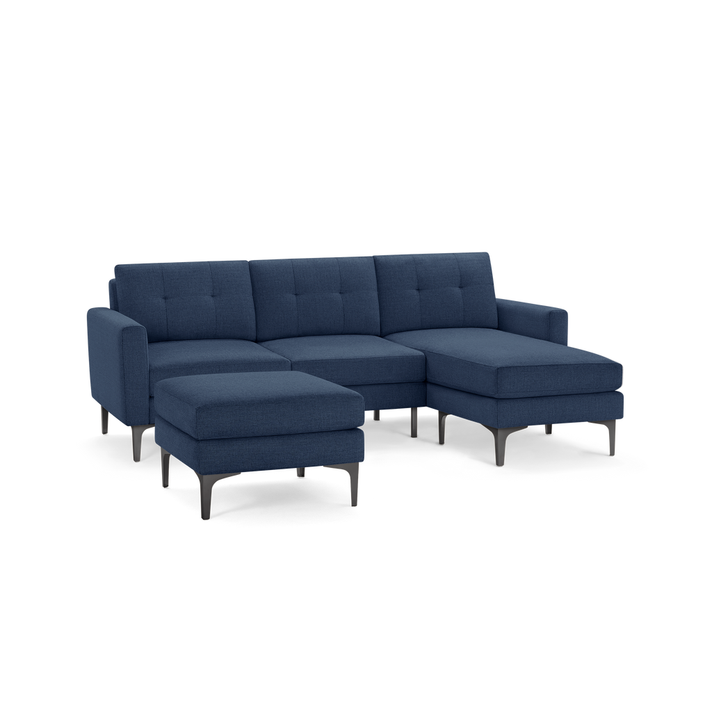 Modern navy blue fabric sectional sofa with tufted cushions, metal legs, and separate matching ottoman.
