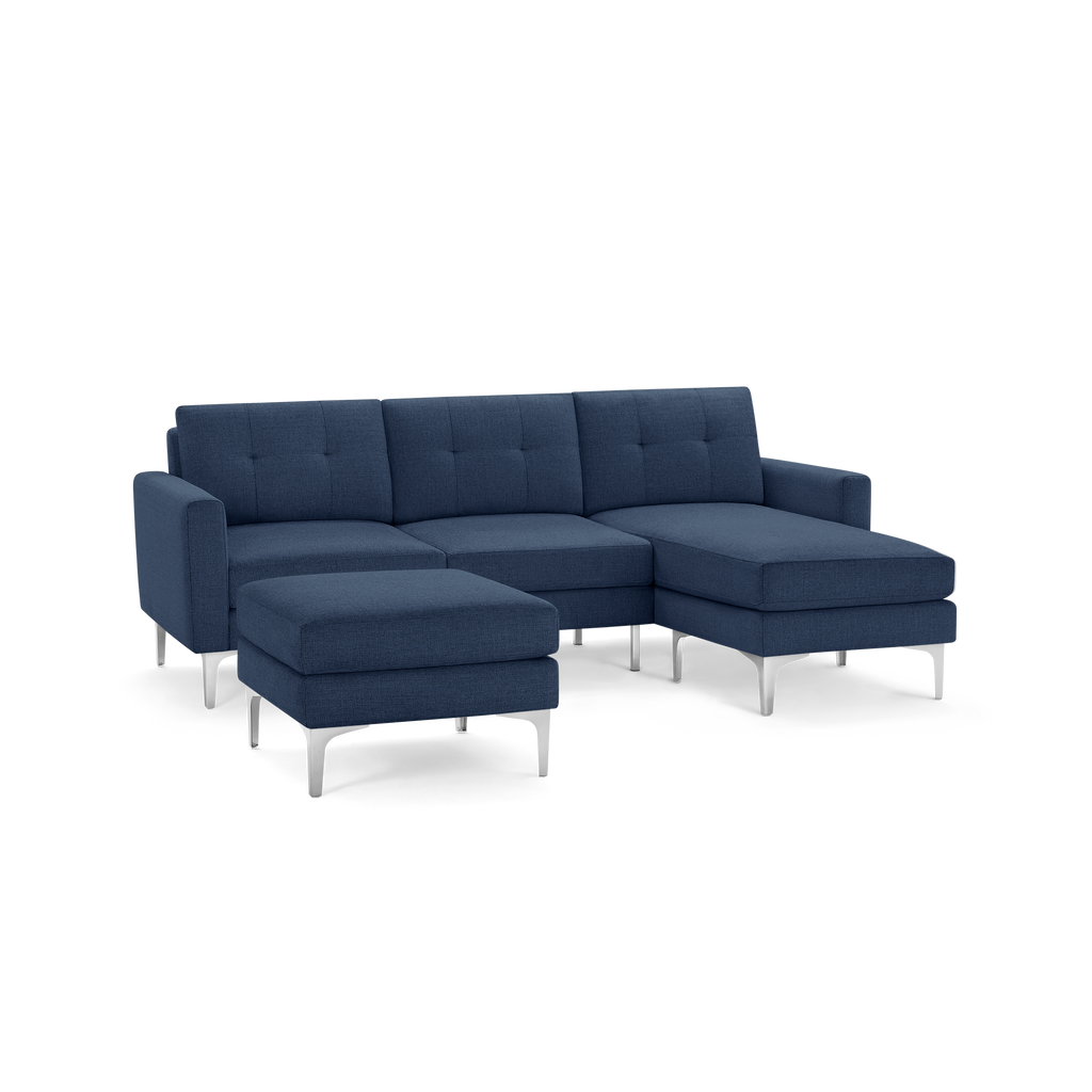 Modern navy blue fabric sectional sofa with tufted back cushions, metal legs, and separate ottoman.