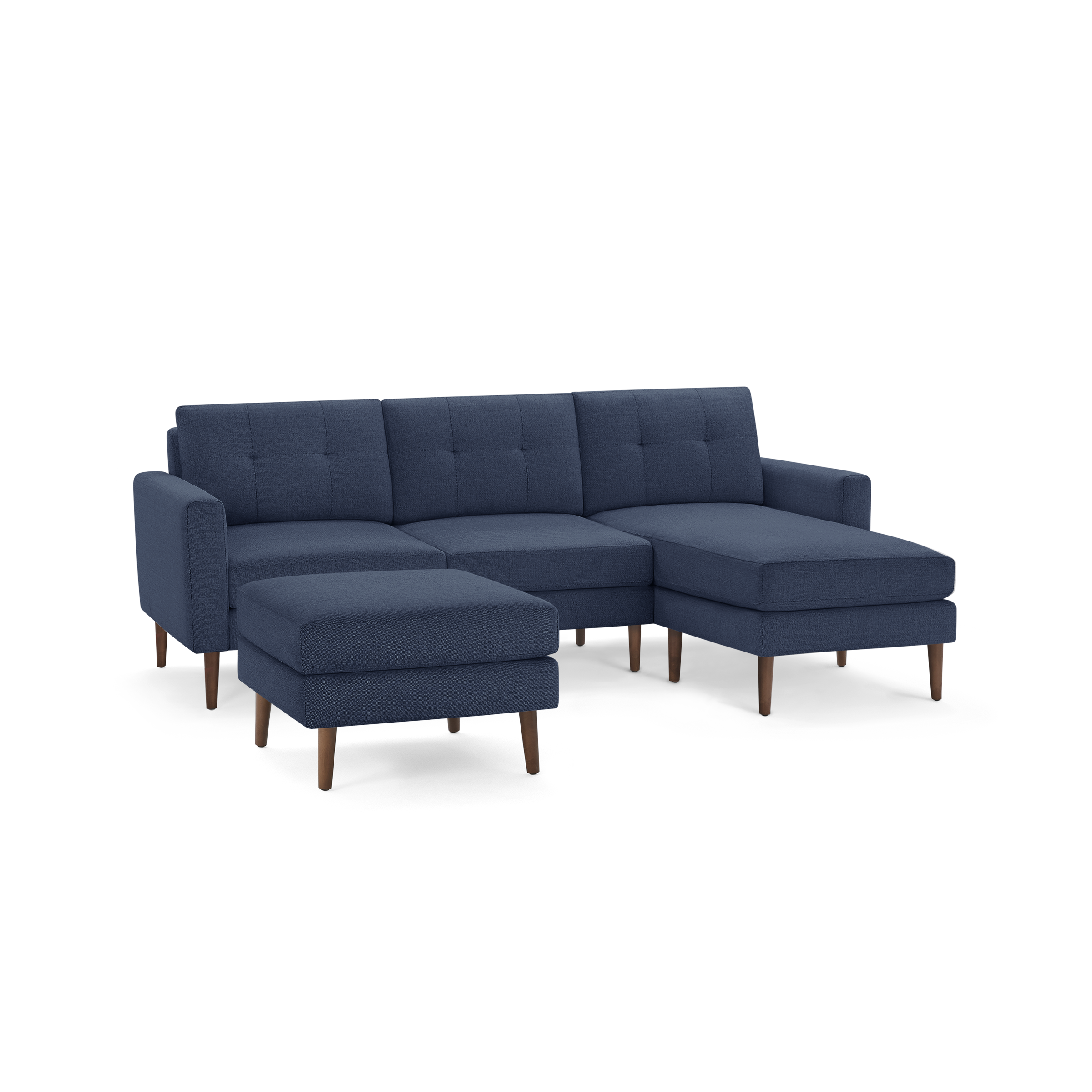 Modern navy blue sectional sofa with tufted back cushions, matching ottoman, and wooden tapered legs, offering comfortable seating.