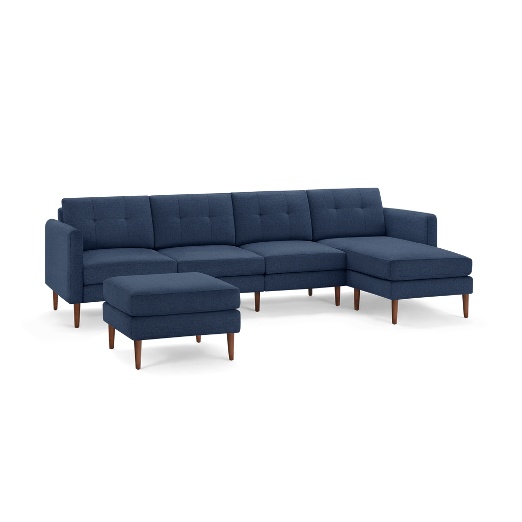 Modern navy blue fabric sectional sofa with wooden legs and a matching upholstered ottoman.