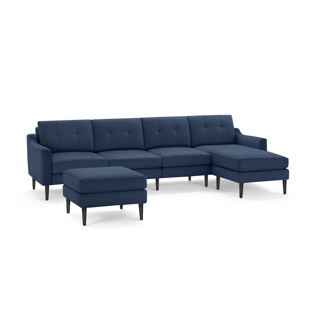 Modern navy blue sectional sofa with tufted back cushions, right chaise, and matching ottoman on black tapered legs.