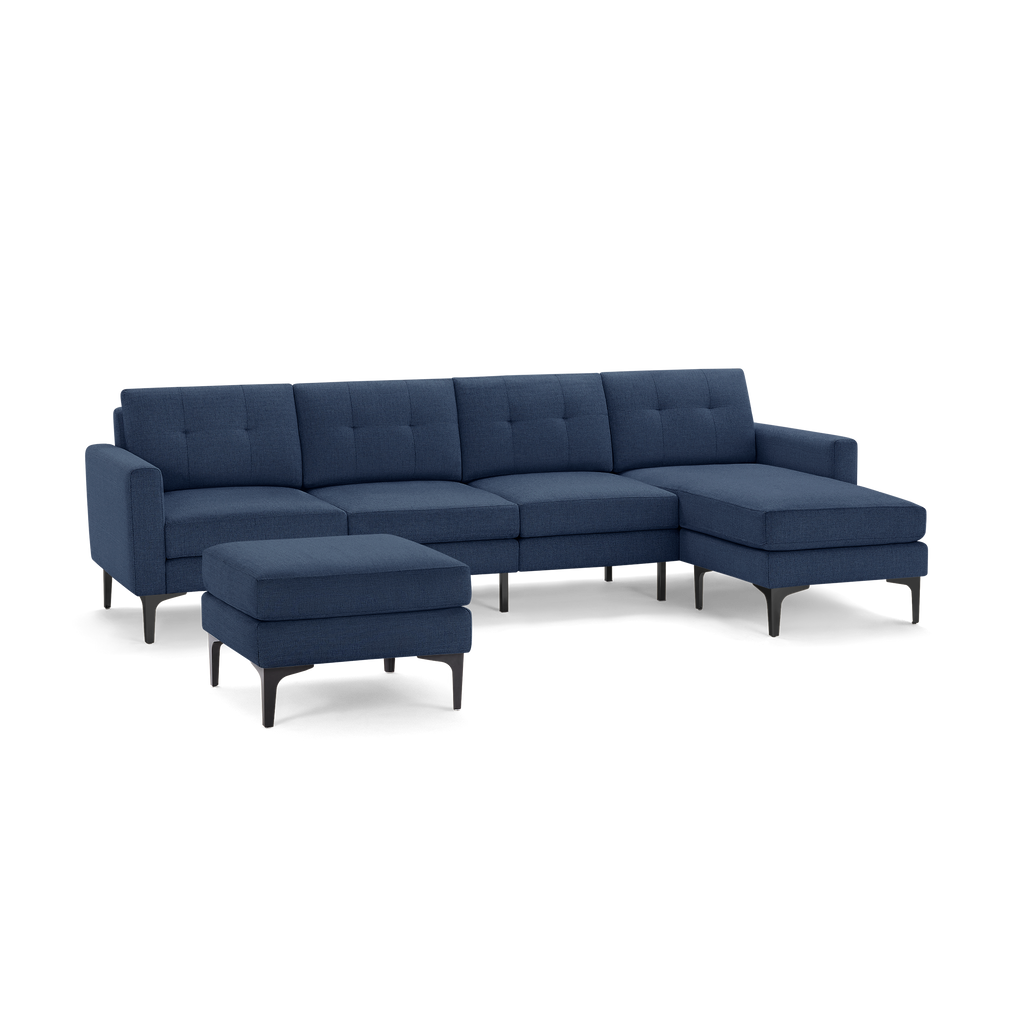 Modern navy blue fabric sectional sofa with chaise lounge and matching ottoman, featuring tufted cushions and black angled legs.