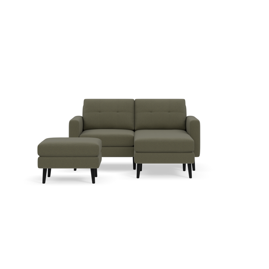Moss green sectional sofa with a matching ottoman, featuring cushioned seats and black tapered legs, set against black background.