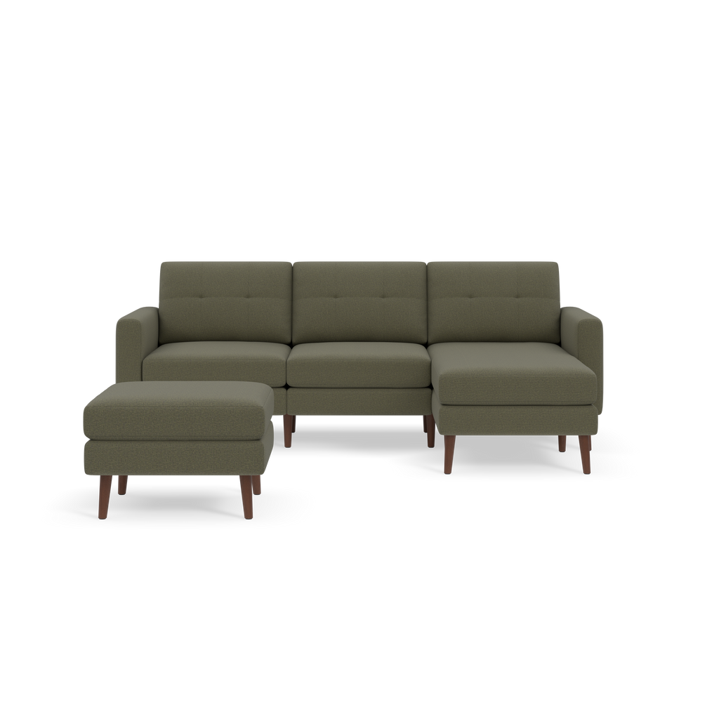 Mid-century modern Moss green fabric sectional sofa with separate ottoman and wooden tapered legs against a black background.