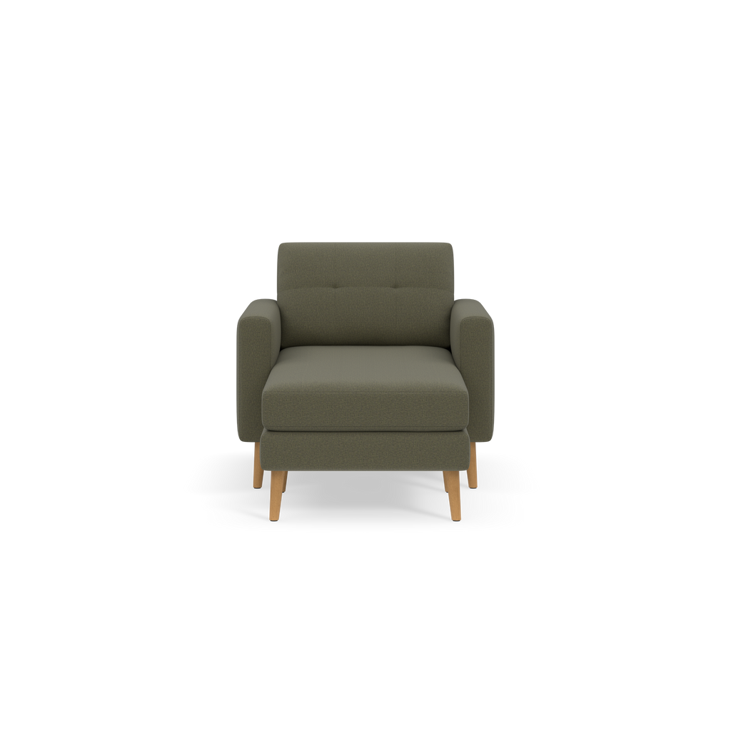 Modern Moss green upholstered armchair with wooden legs, wide seat cushion, and padded armrests, shown against a black background.