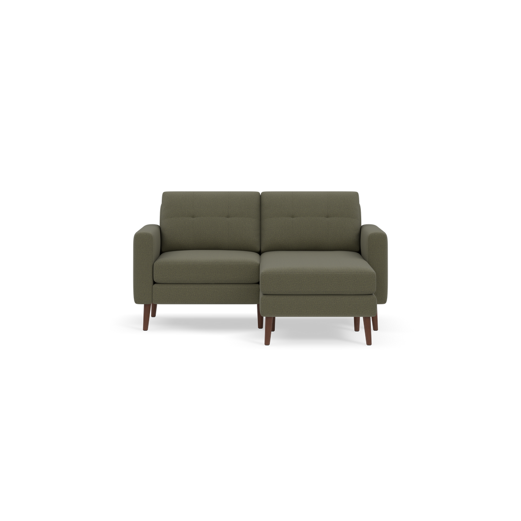 Modern Moss green upholstered sectional sofa with wooden legs and tufted back cushions, set against a black background.
