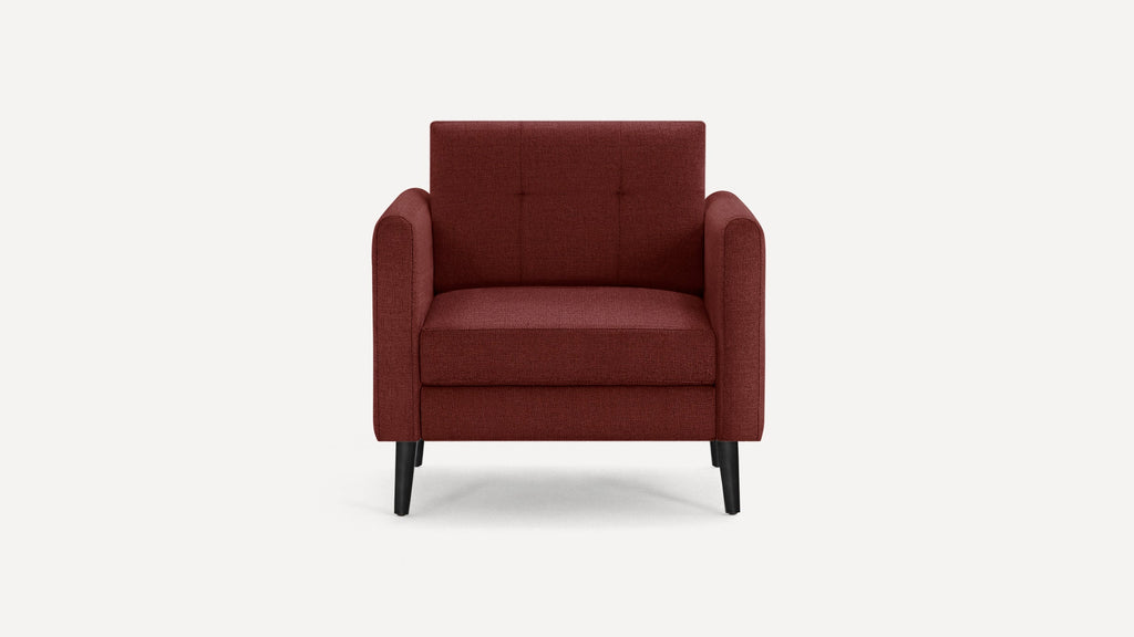 Front view of a modern, deep red upholstered armchair with square arms and black tapered legs on a white background.