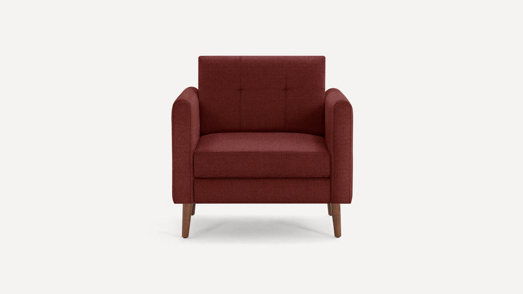 Front view of a modern deep red upholstered armchair with wooden tapered legs and tufted backrest.