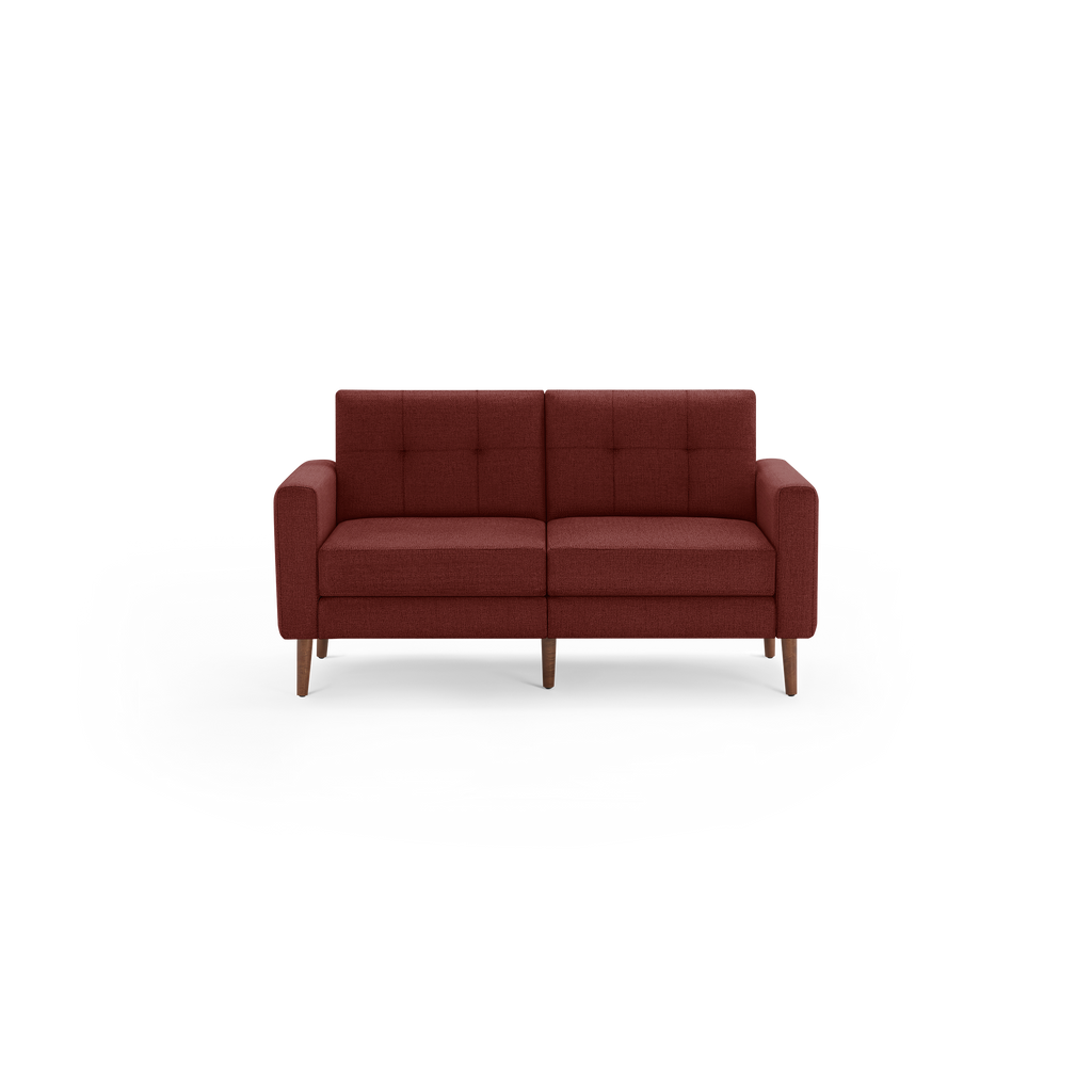 Mid-century modern two-seater sofa in deep red fabric with tufted backrest and wooden tapered legs.
