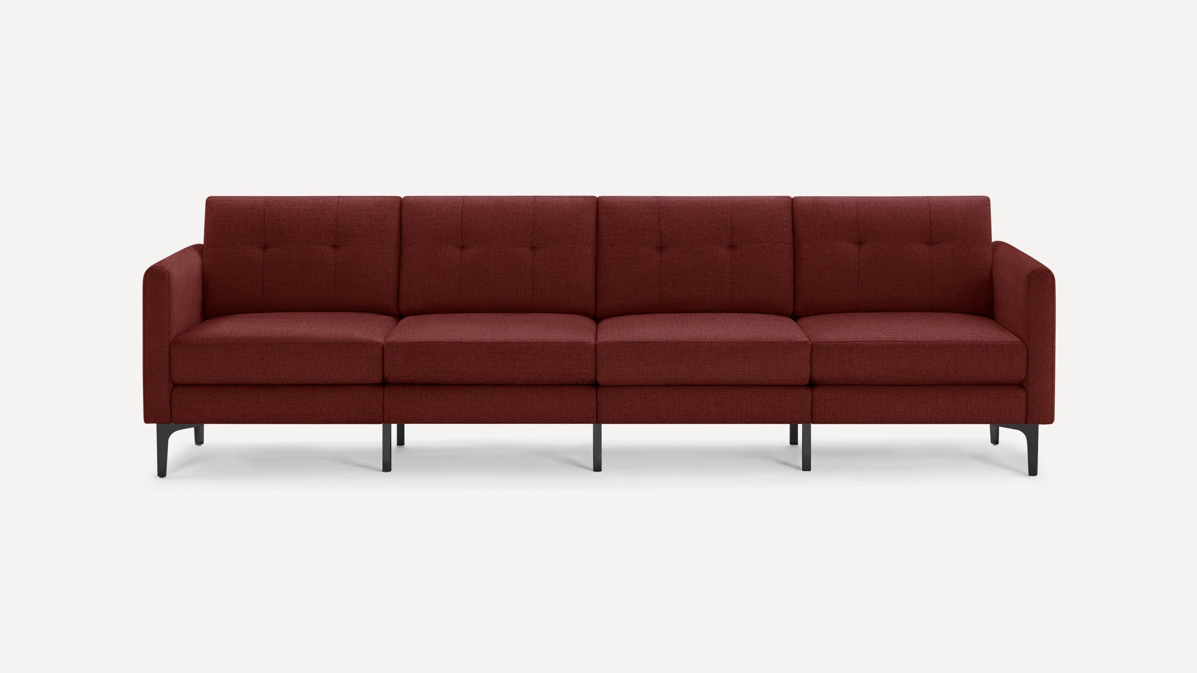 Modern four-seater sofa in dark red fabric with button-tufted back cushions and slim black metal legs.