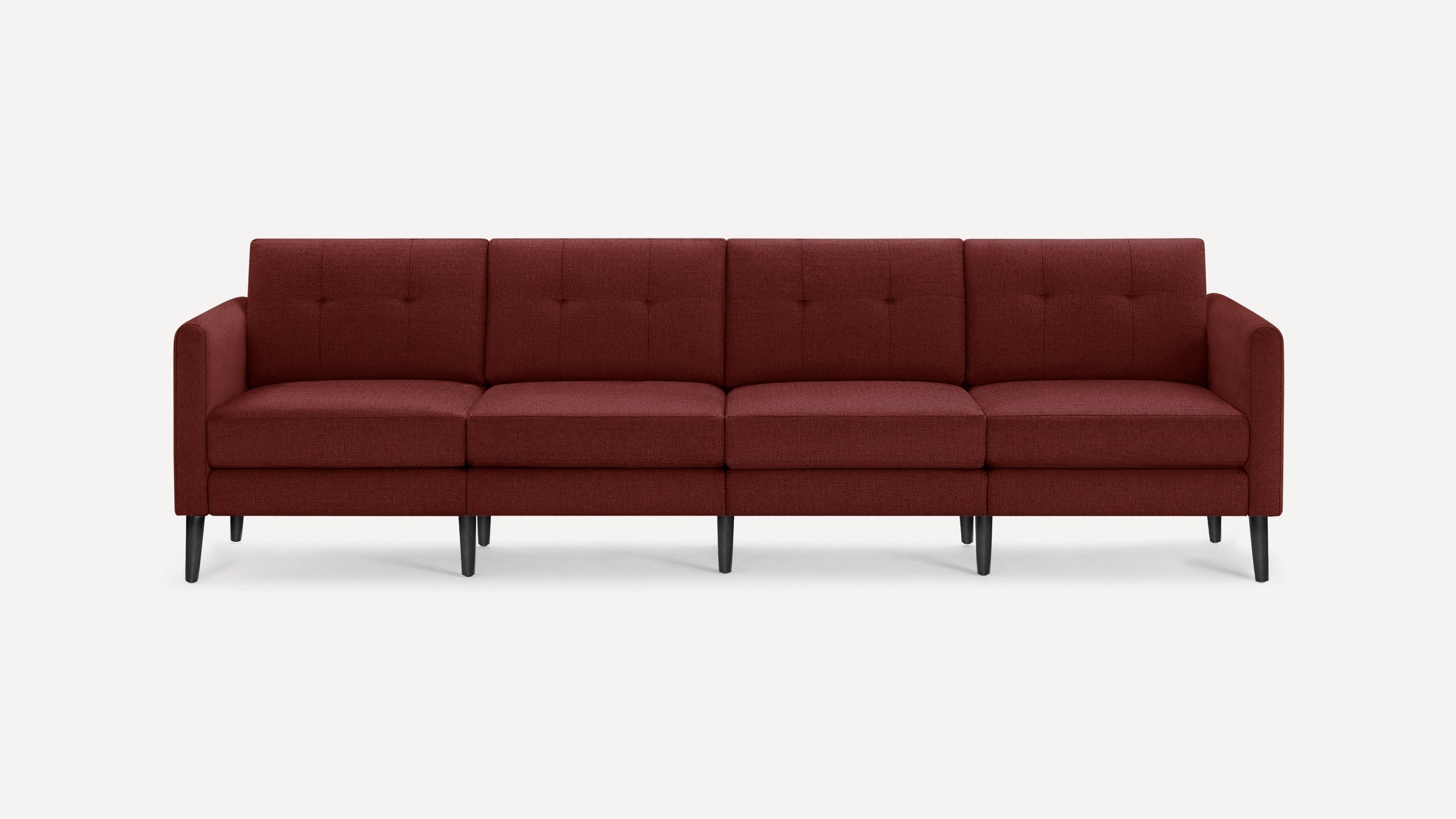 Four-seater modern sofa upholstered in deep red fabric with tufted backrests and slim black tapered legs, shown on a white background.