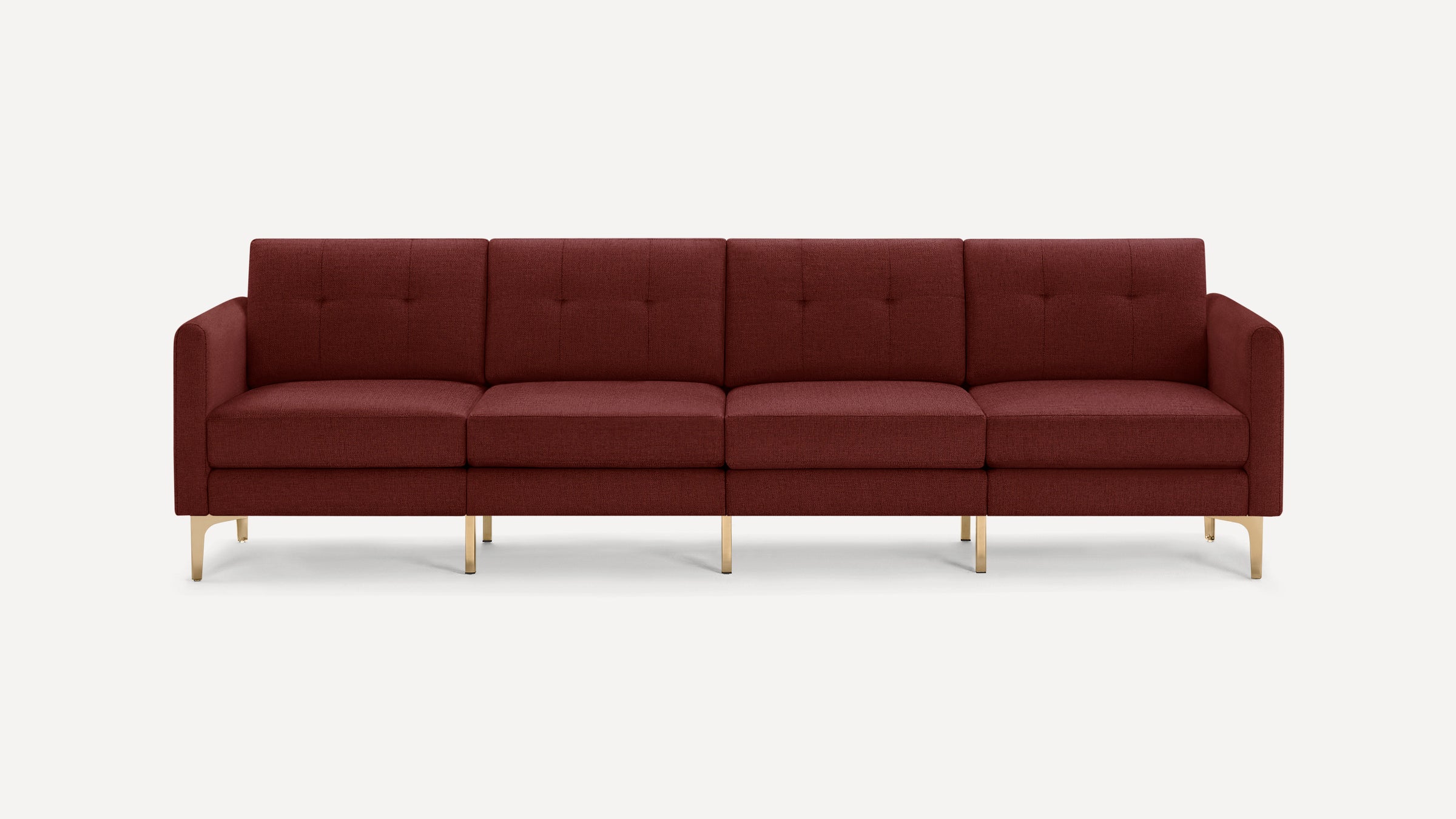 Four-seat modern sofa upholstered in deep burgundy fabric with button-tufted back cushions and brass metal legs.
