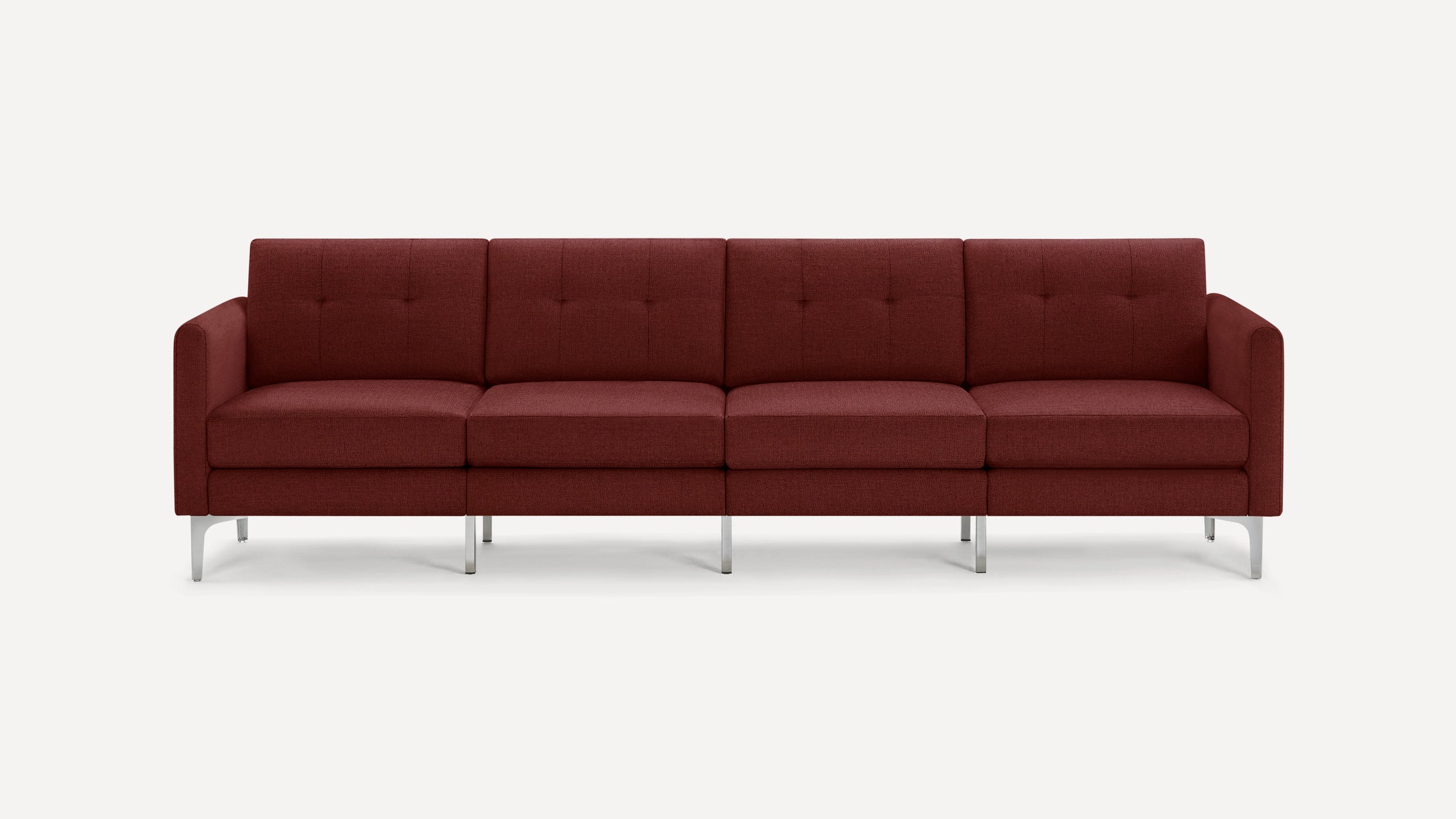 Modern four-seater sofa in deep red fabric with button-tufted back cushions and sleek metal legs on white background.