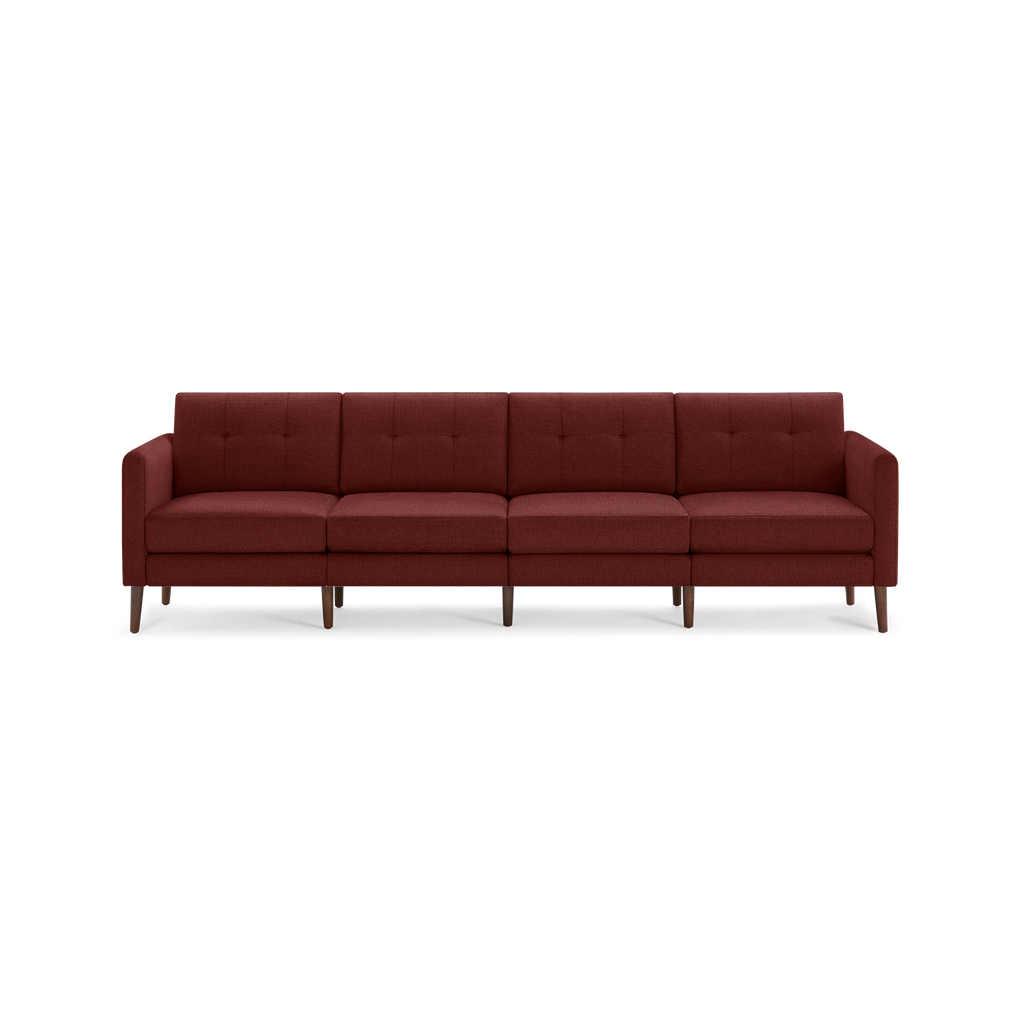 Modern, four-seater sofa upholstered in deep red fabric with tufted back cushions and wooden tapered legs.