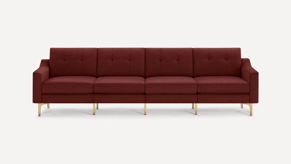 Modern four-seater sofa in deep burgundy fabric with tufted back cushions and sleek gold metal legs, minimalist design.