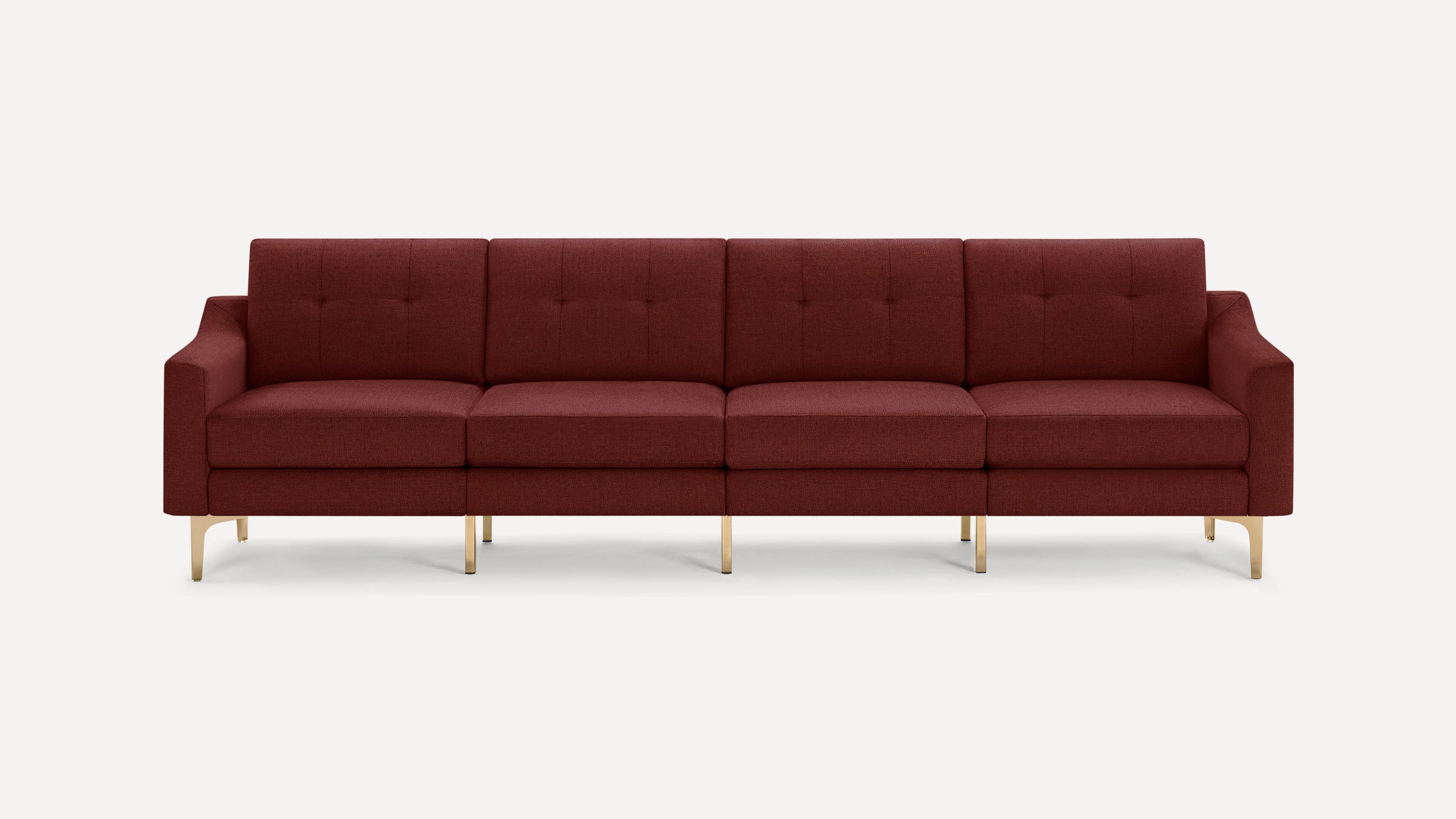 Modern four-seater sofa in deep burgundy fabric with tufted back cushions and sleek gold metal legs, minimalist design.