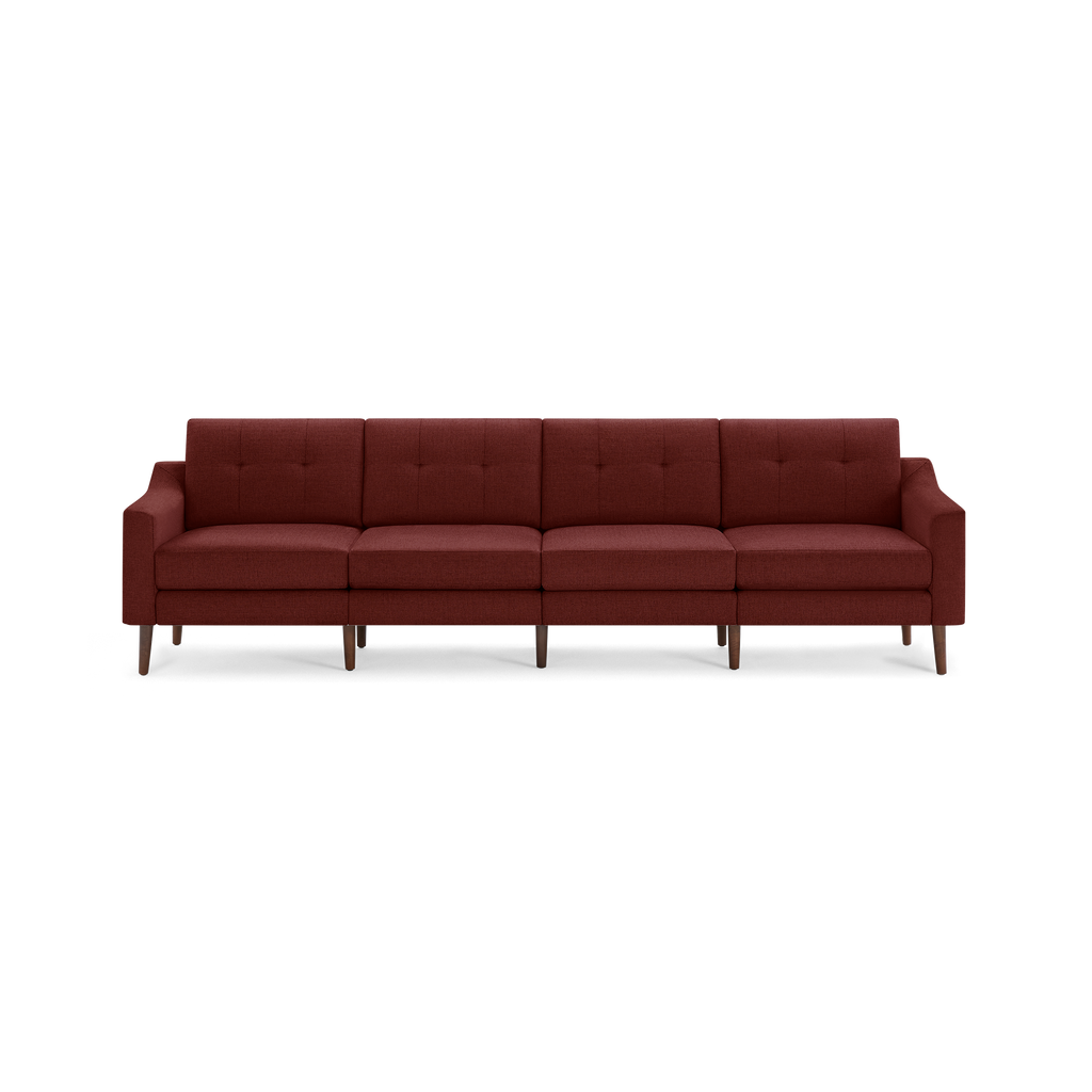 Wide modern four-seater sofa with burgundy fabric upholstery, tufted back cushions, and tapered wooden legs.