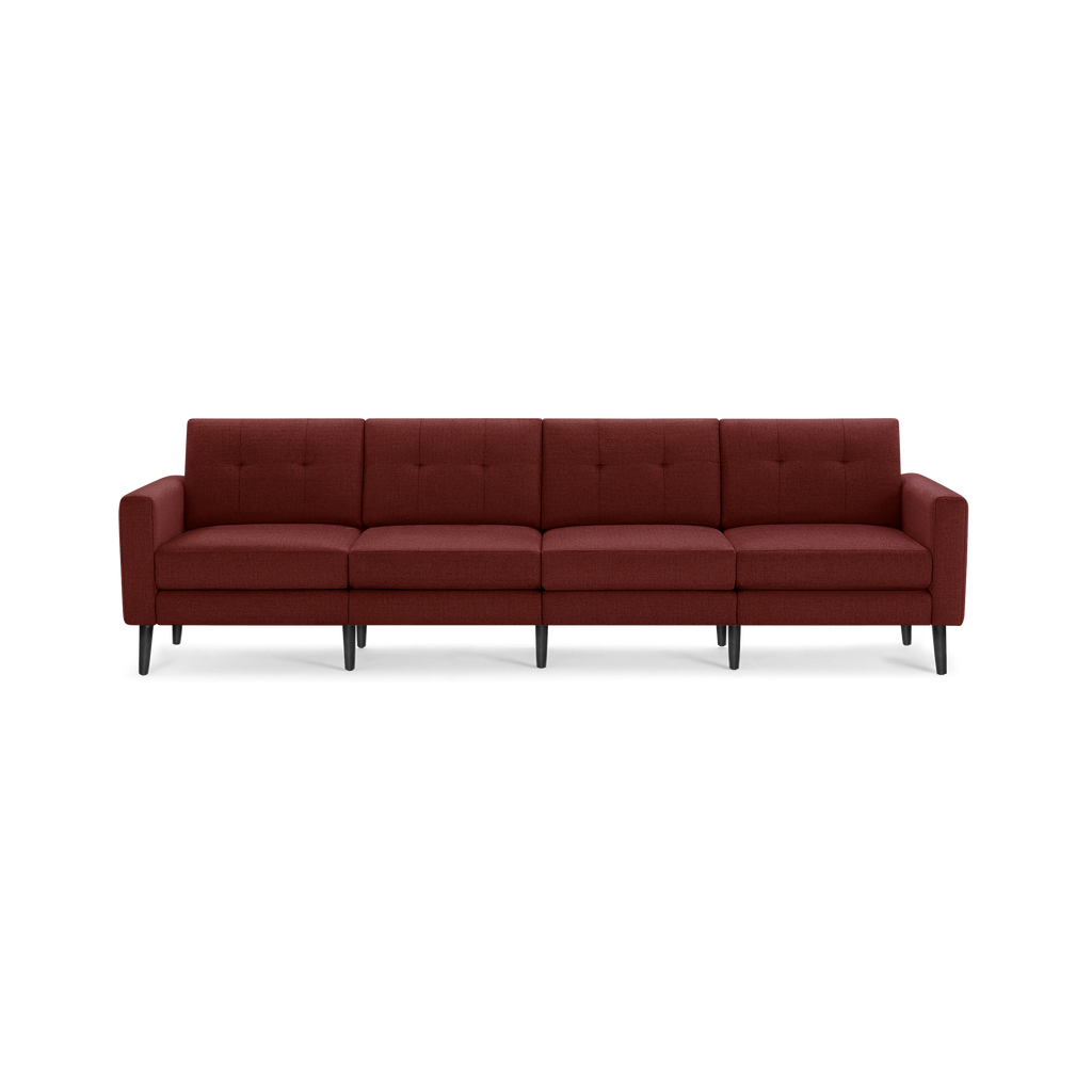 Modern four-seater sofa in deep red fabric with tufted back cushions and black tapered wooden legs.