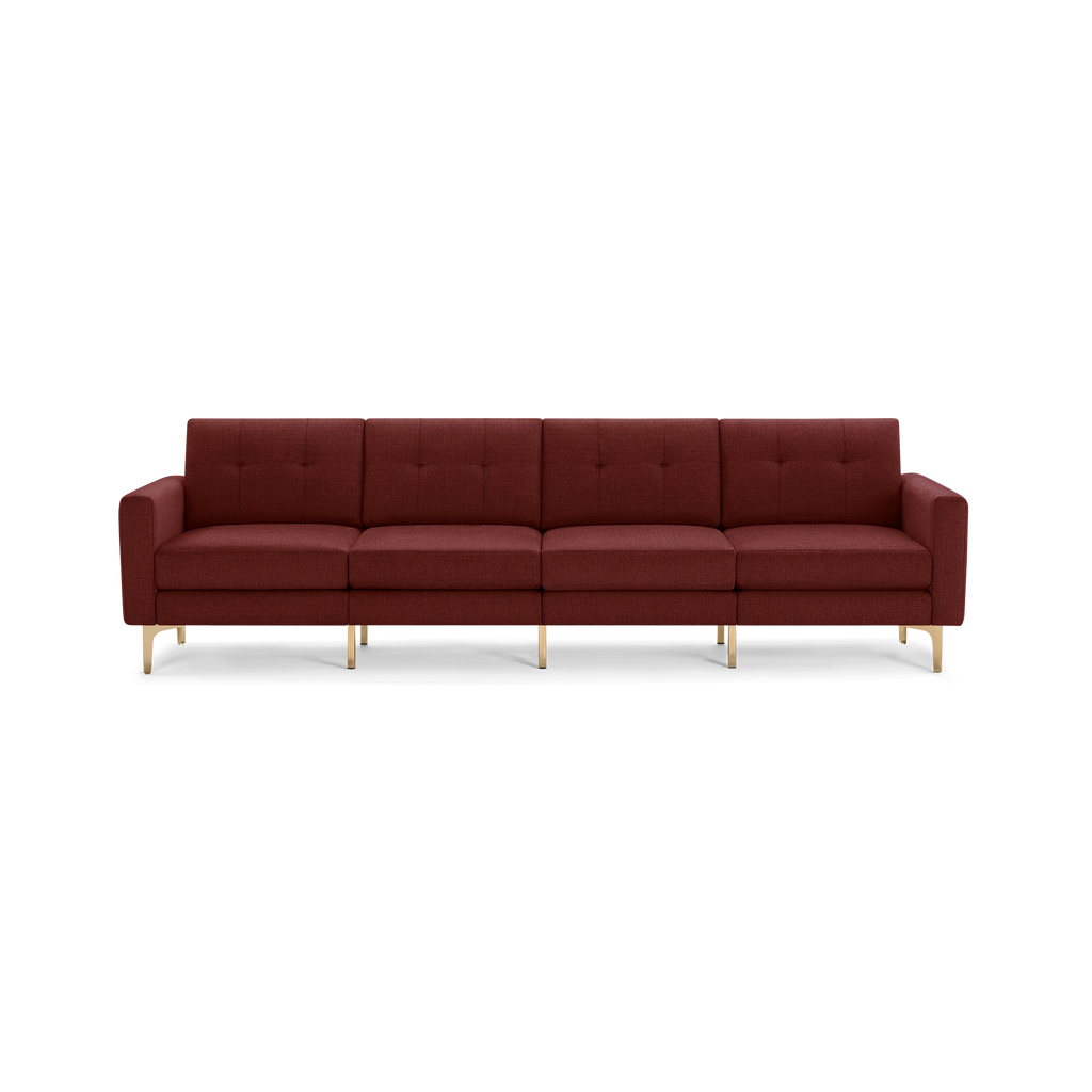 Modern four-seater sofa in deep burgundy fabric with tufted back cushions and sleek gold metal legs.