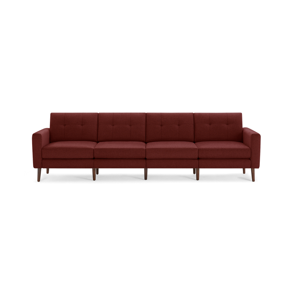 Wide four-seater sofa with dark red fabric upholstery, button-tufted back cushions, slim armrests, and tapered wooden legs.