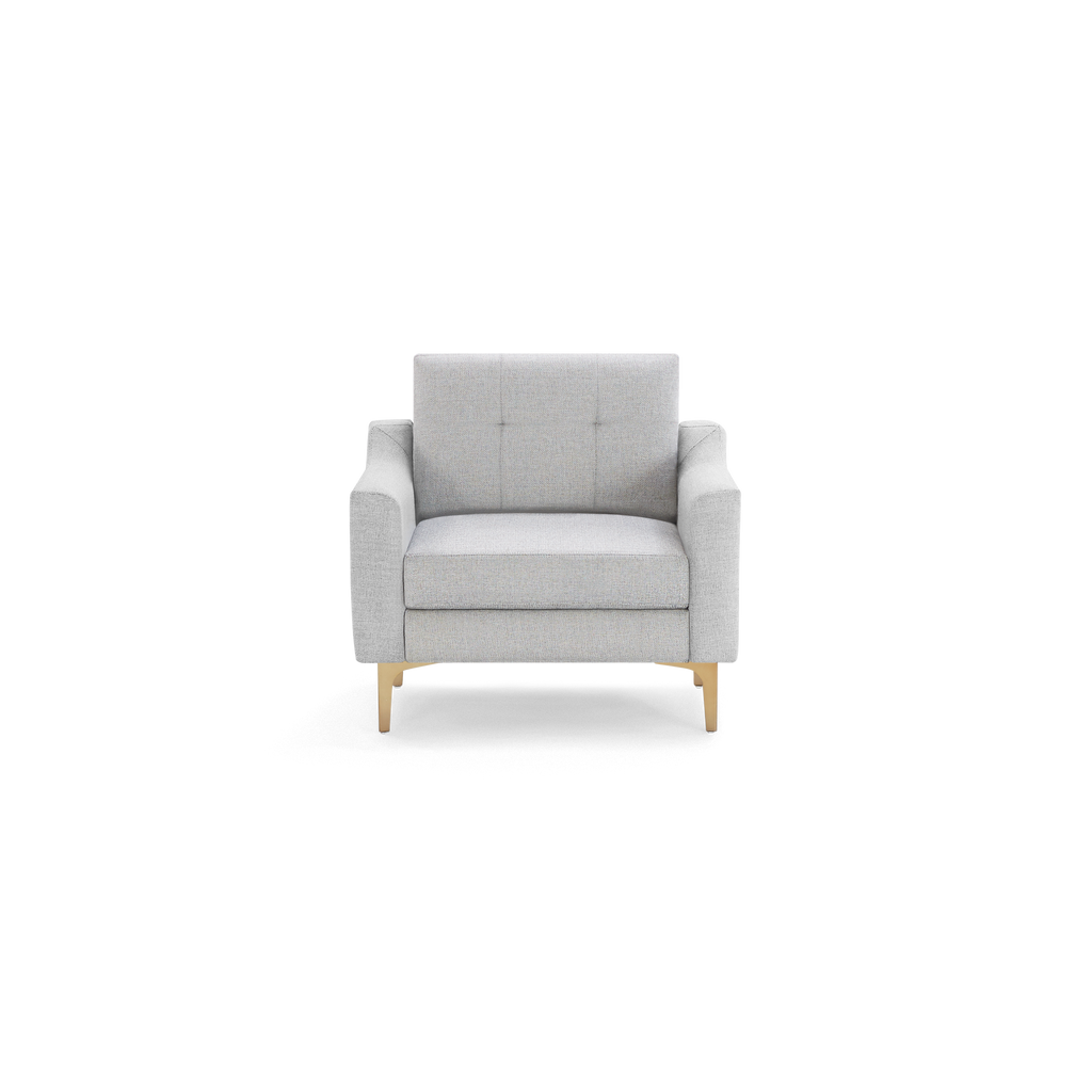 Light gray upholstered armchair with square tufted backrest and wooden tapered legs, shown on a black background.