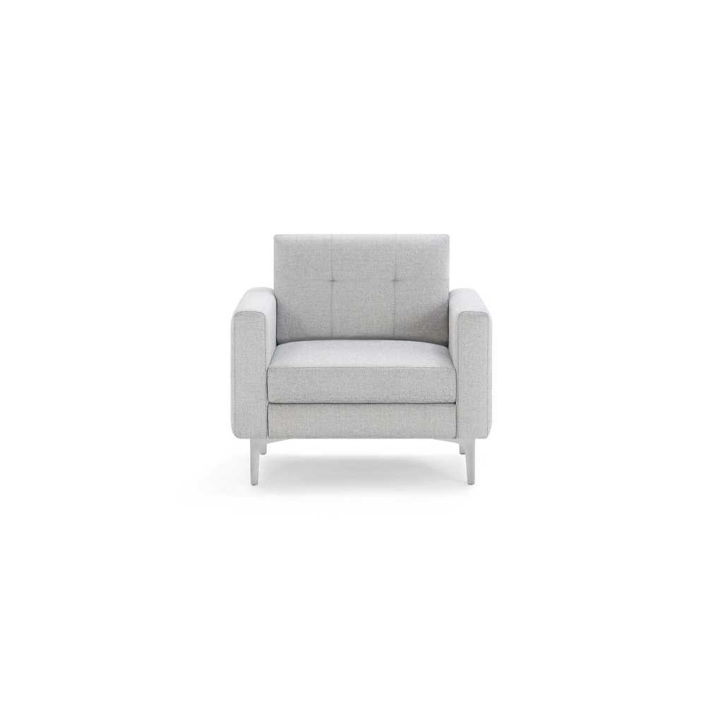 Light grey fabric armchair with square arms, tufted backrest, thick seat cushion, and slim metal legs.