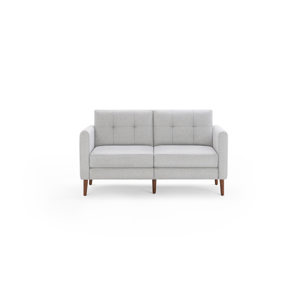 Light gray upholstered mid-century modern loveseat with tufted backrests and wooden tapered legs on black background.