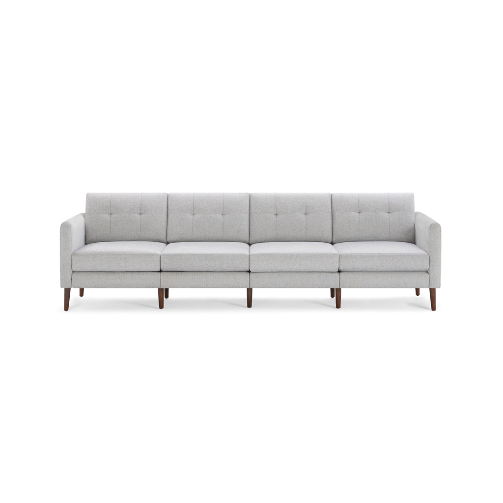 Light gray modern four-seater sofa with tufted back cushions, straight arms, and wooden legs on a black background.