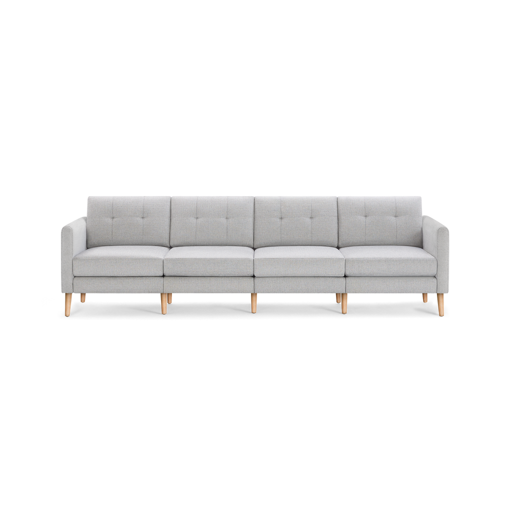 Light gray modern four-seater sofa with tufted back cushions and wooden legs, featuring clean lines and armrests on both ends.