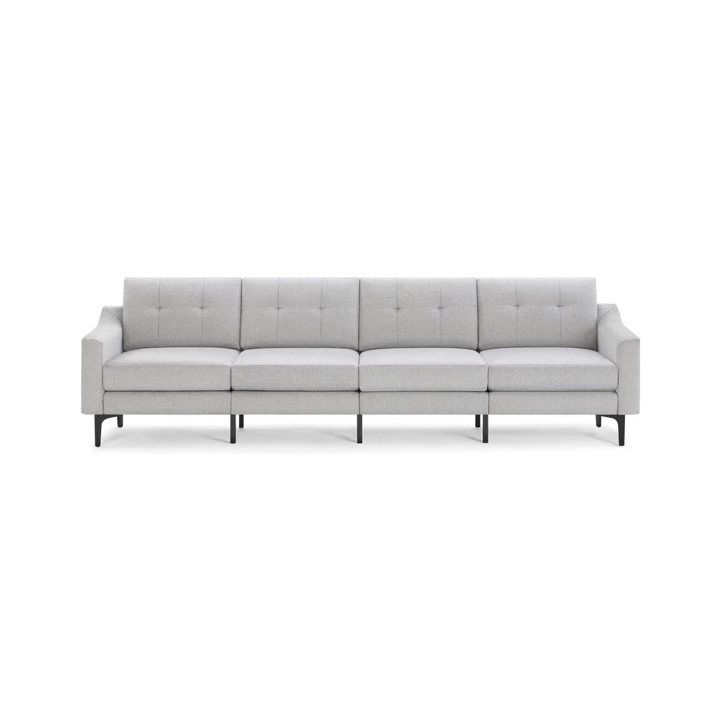 Light gray four-seat modern sofa with tufted back cushions, straight arms, and black metal legs on a black background.