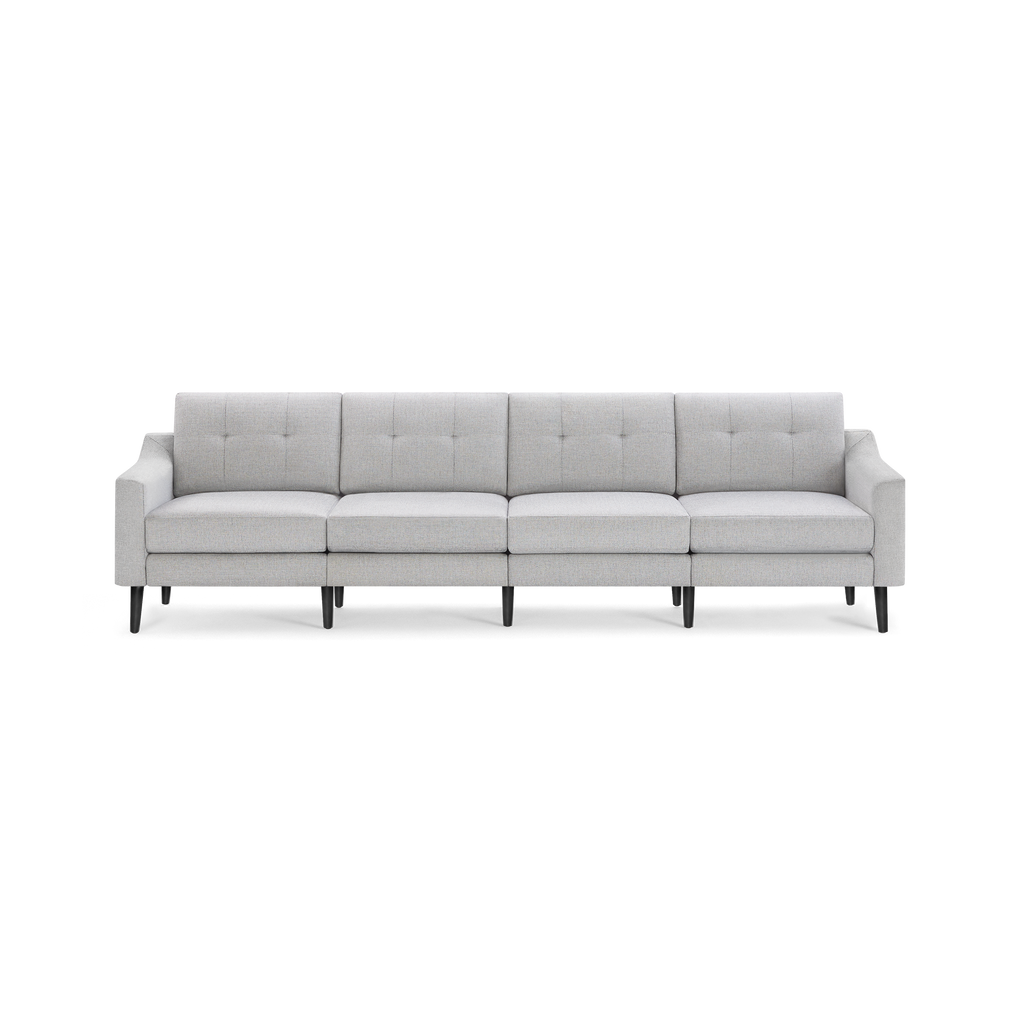 Light gray, modern four-seat sofa with tufted back cushions and black wooden legs on a black background.