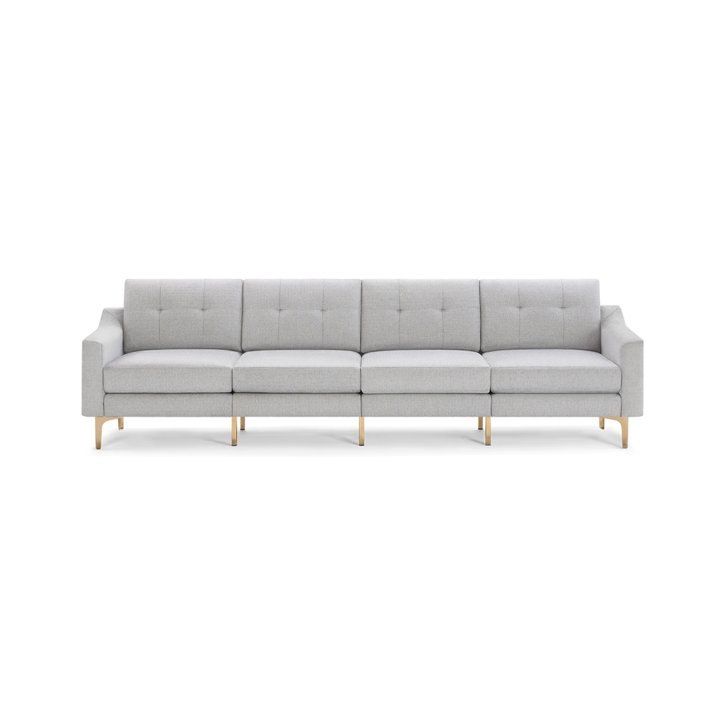 Light gray four-seater modern sofa with tufted back cushions, slim rectangular armrests, and sleek gold metal legs on a black background.
