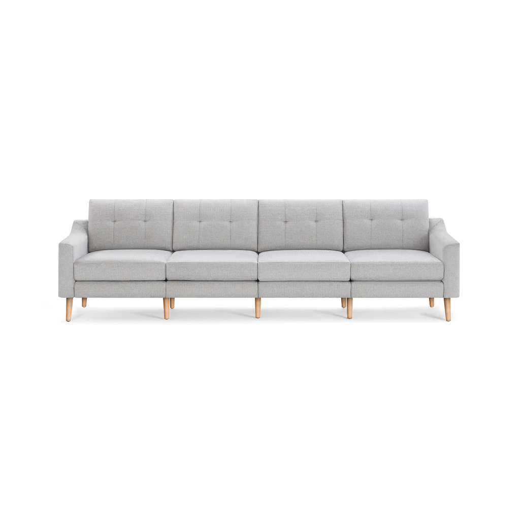 Light gray modern four-seat sofa with wooden legs, straight arms, and button-tufted back cushions on a black background.