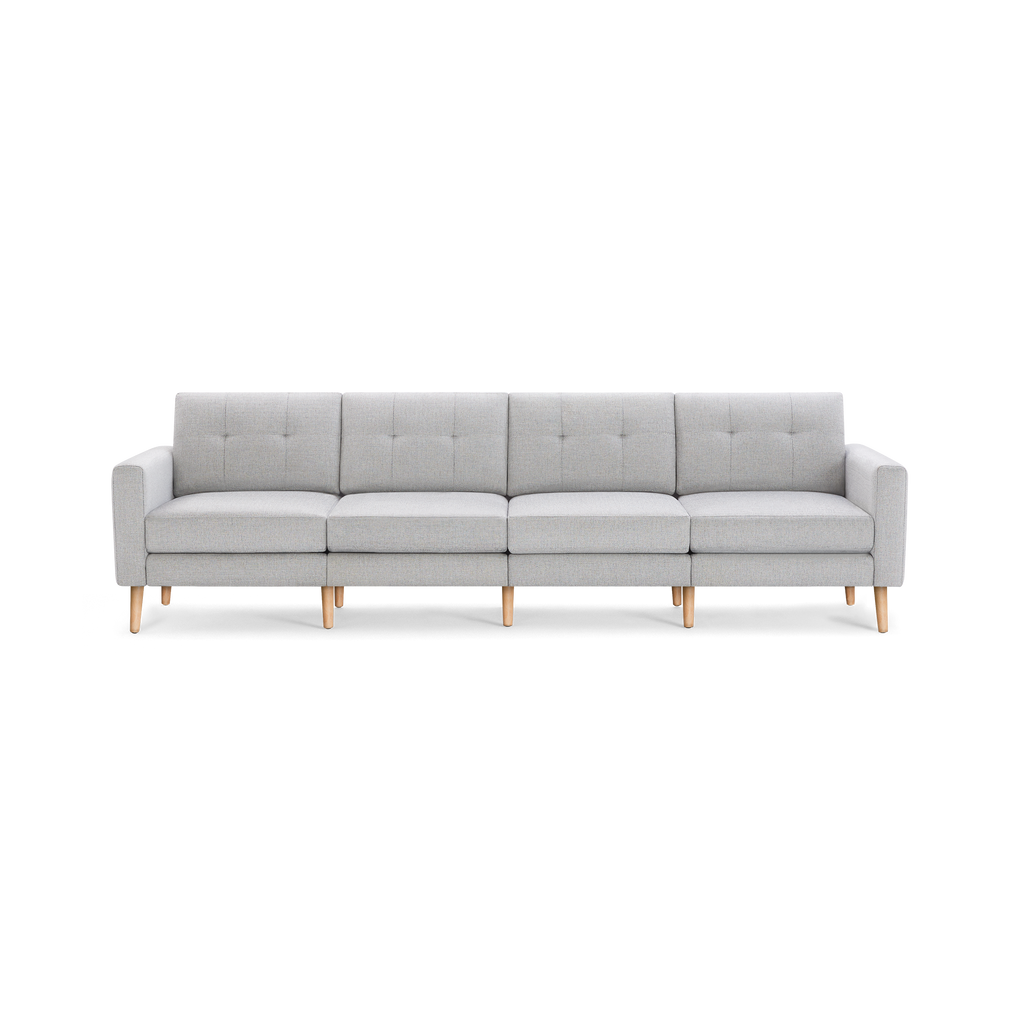 Light gray modern four-seater sofa with wooden legs, tufted back cushions, and clean, straight armrests.