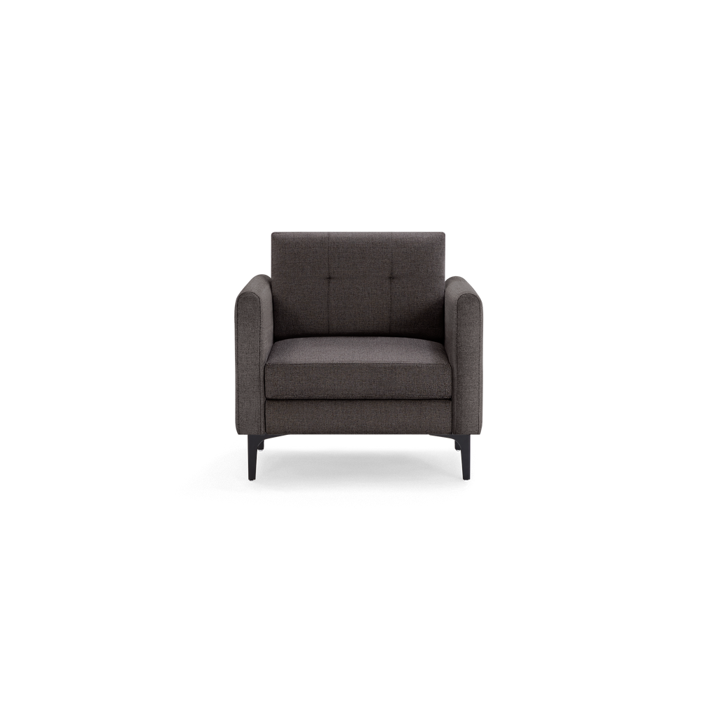 Dark gray upholstered armchair with tufted backrest, cushioned seat, rounded arms, and black tapered legs, shown on black background.