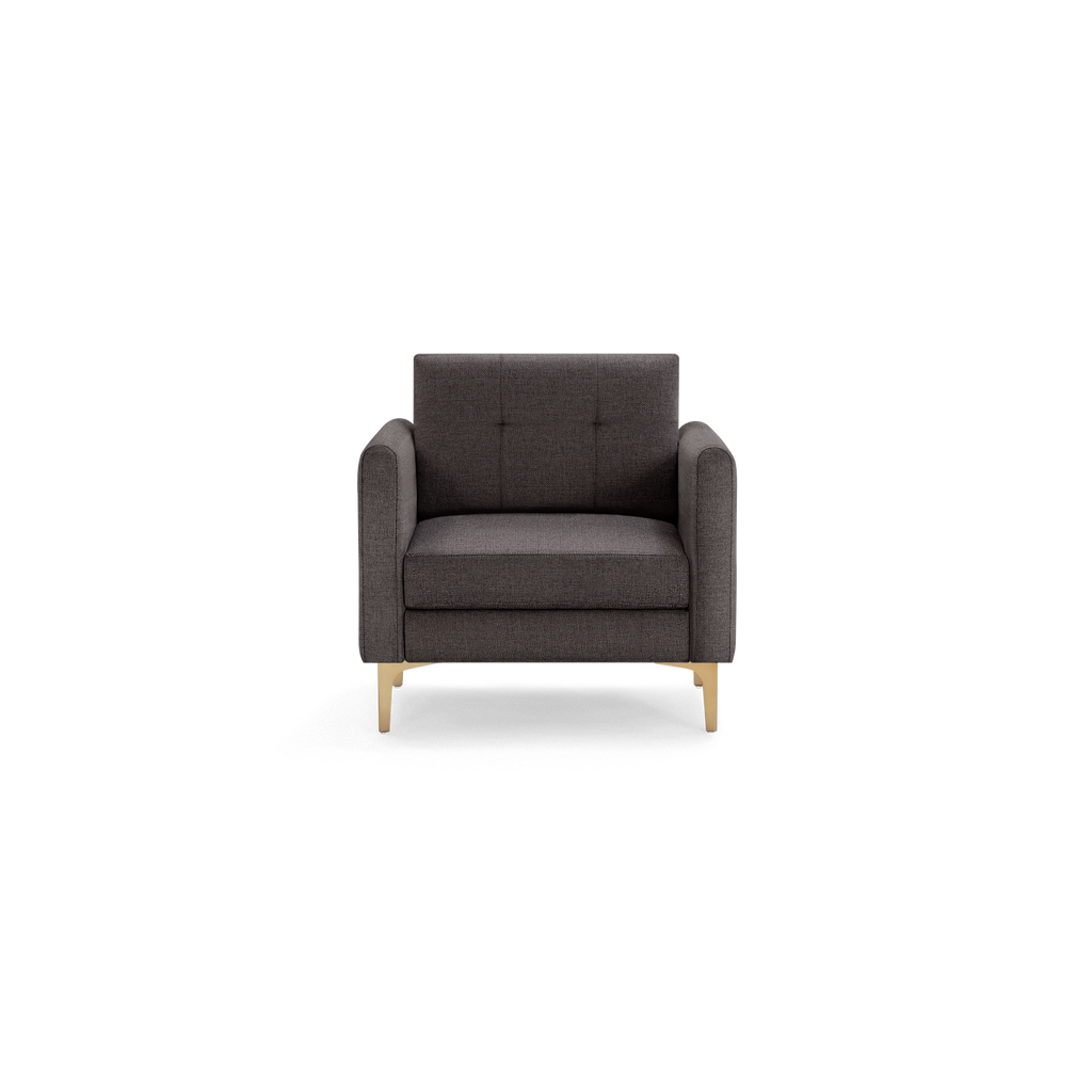Dark gray modern armchair with tufted backrest, cushioned seat, and light wooden legs, shown on a black background.
