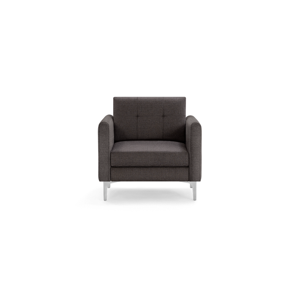 Front view of a modern dark gray armchair with tufted backrest and sleek metal legs against a black background.