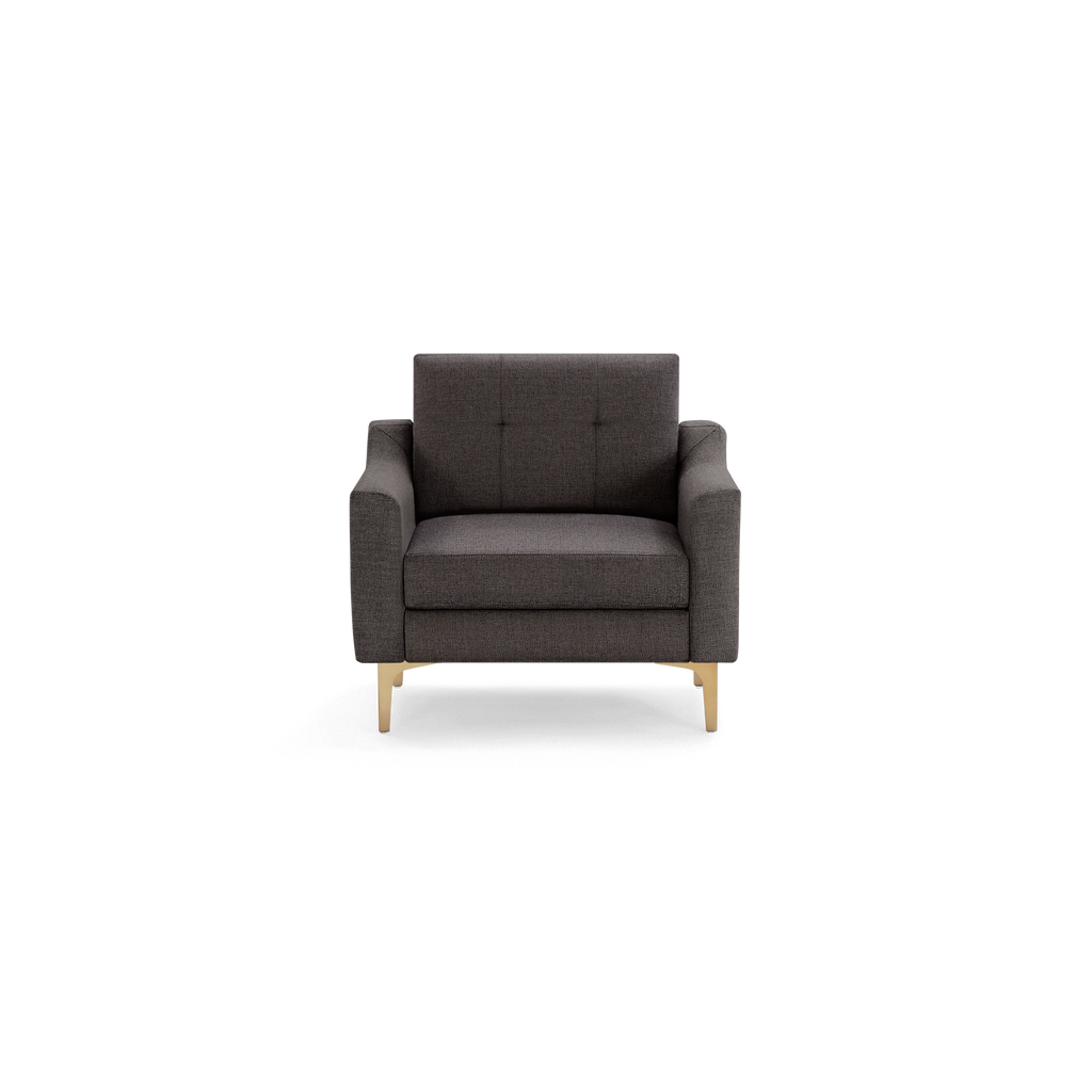 Dark gray upholstered armchair with square tufted backrest, cushioned seat, slim armrests, and light wooden legs.