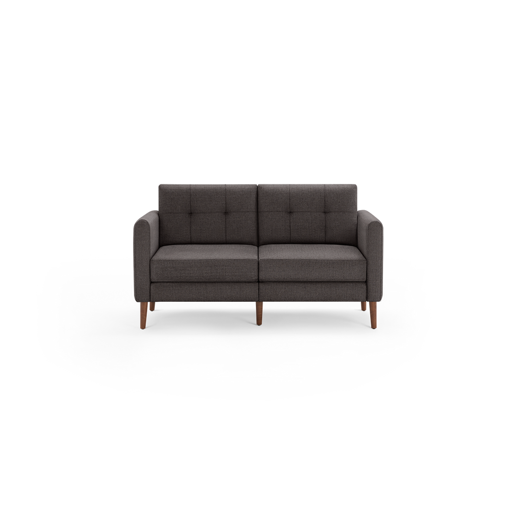 Modern dark gray fabric loveseat sofa with tufted backrest and wooden tapered legs against black background.