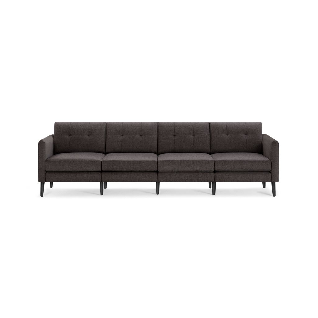 Dark gray modern four-seater sofa with tufted back cushions and slim, black wooden legs.