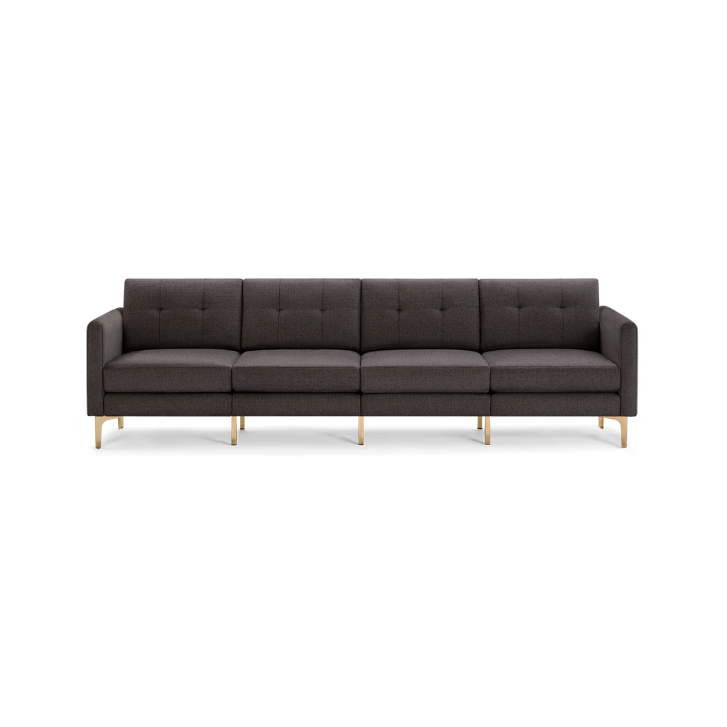 Four-seater modern dark gray fabric sofa with tufted back cushions and sleek gold metal legs on black background.