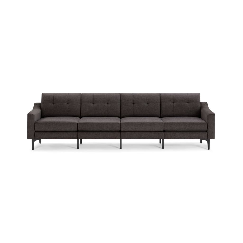 Dark gray modern four-seater sofa with tufted back cushions, straight arms, and black metal legs on black background.
