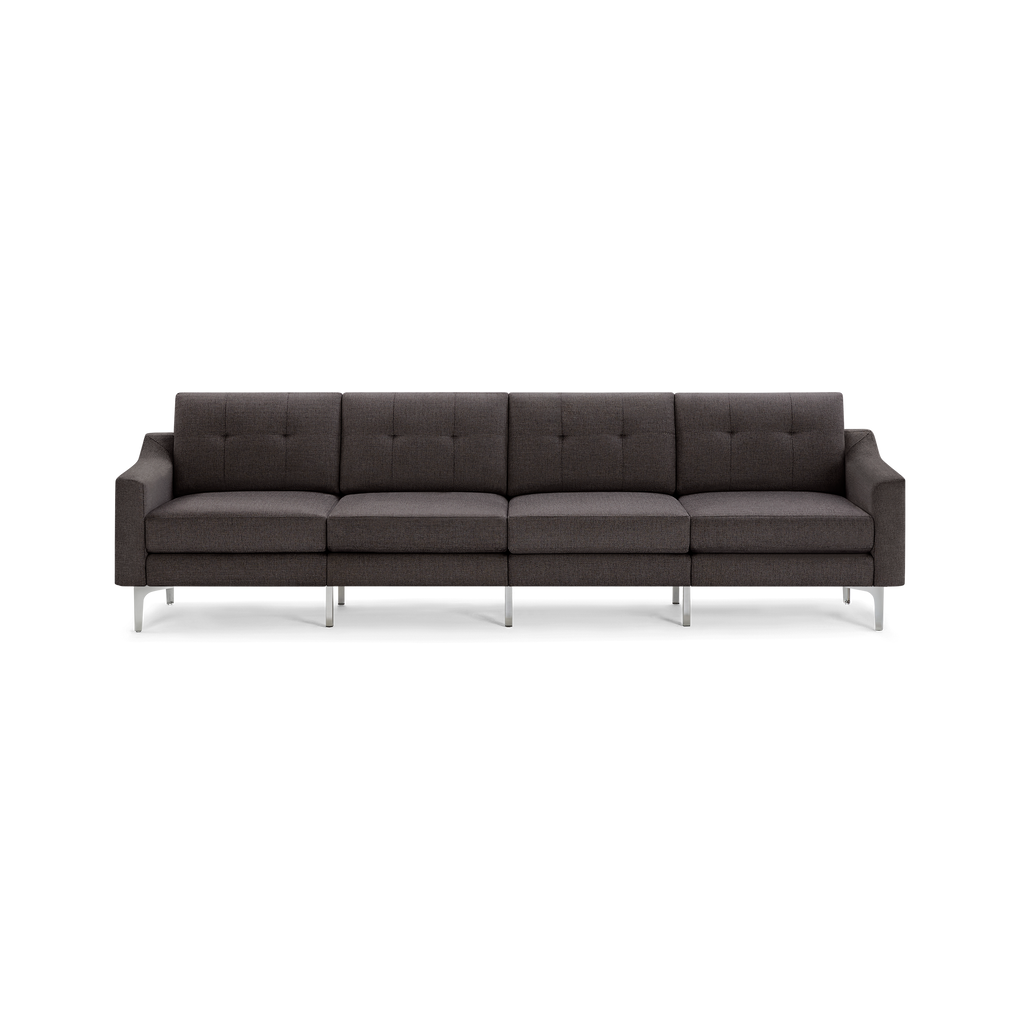 Dark gray fabric four-seater sofa with tufted back cushions, straight armrests, and sleek metallic legs.