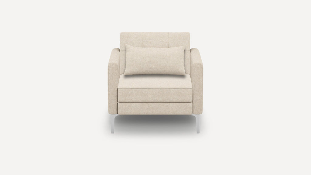 Front view of a modern beige fabric armchair with a rectangular lumbar pillow and sleek metal legs on a white background.