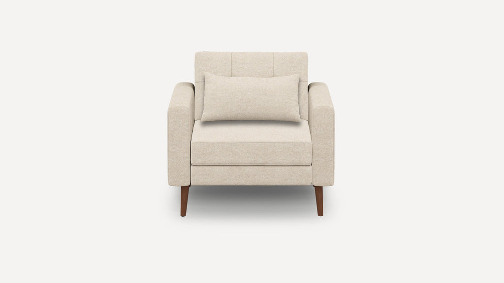 Beige upholstered armchair with straight arms, a rectangular lumbar pillow, and four tapered wooden legs.